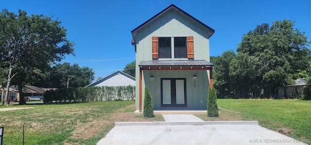 view of front of house with a front yard and an outbuilding