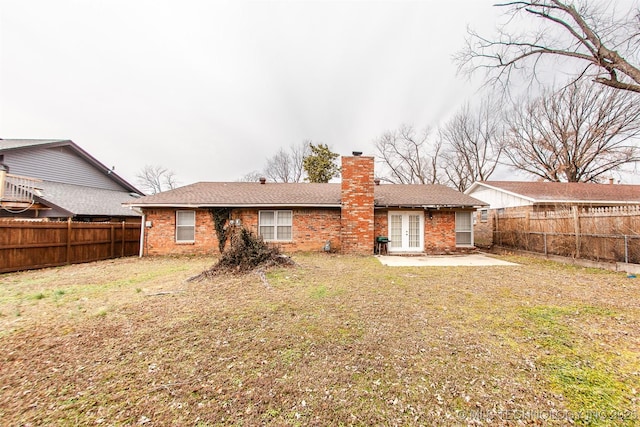 back of house featuring french doors, a patio, and a lawn