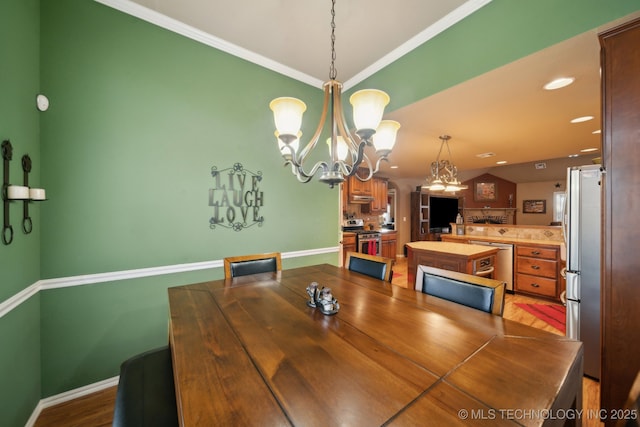 dining area with wood-type flooring, lofted ceiling, a chandelier, and crown molding