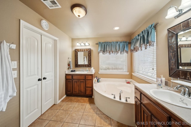 bathroom with tile patterned flooring, vanity, and a bathtub