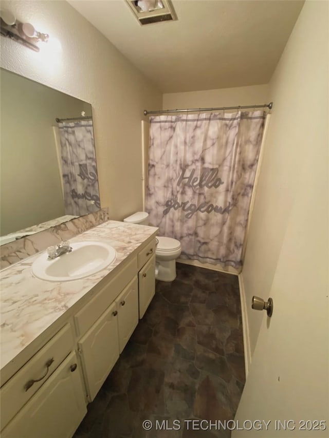 bathroom with toilet, vanity, and curtained shower