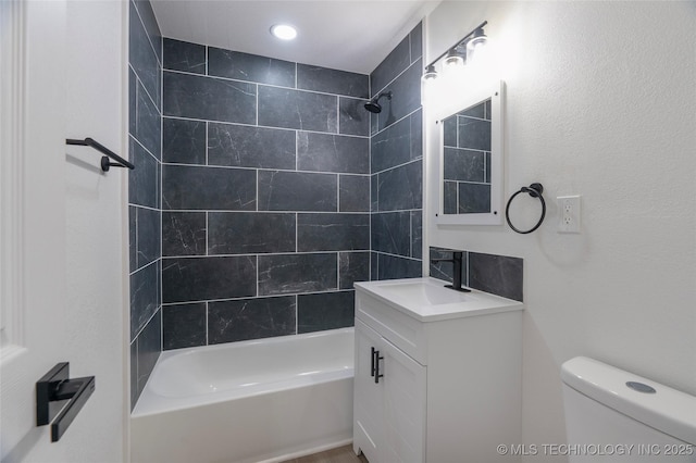 full bathroom featuring vanity, tiled shower / bath combo, and toilet