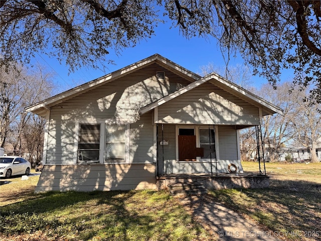 bungalow-style home featuring a porch and a front yard