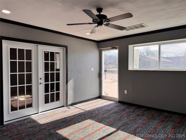 carpeted empty room featuring ceiling fan, french doors, ornamental molding, and a textured ceiling