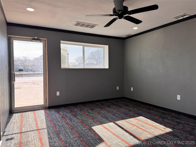 spare room featuring ceiling fan, ornamental molding, and dark colored carpet