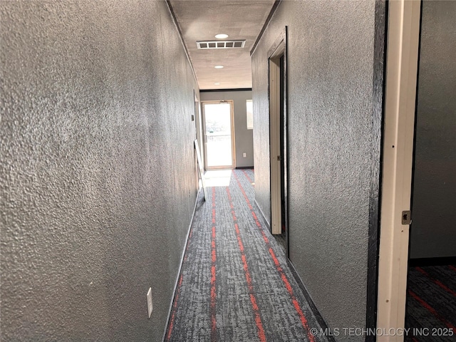 hallway with dark colored carpet