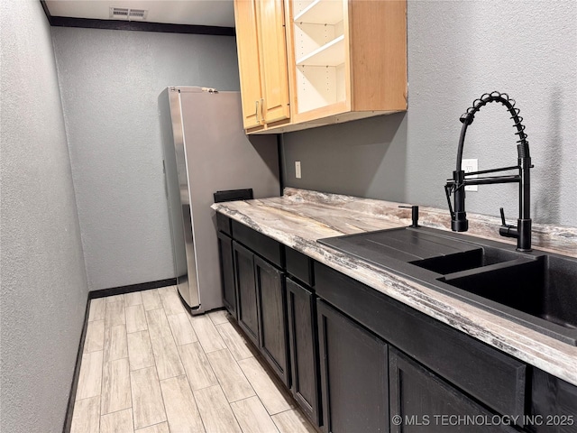 kitchen featuring stainless steel fridge and sink