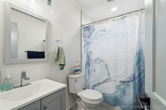 bathroom featuring toilet, vanity, and walk in shower