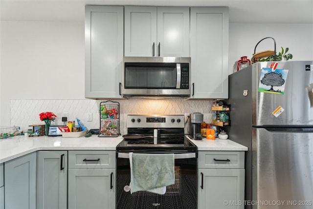 kitchen with backsplash, appliances with stainless steel finishes, and gray cabinets