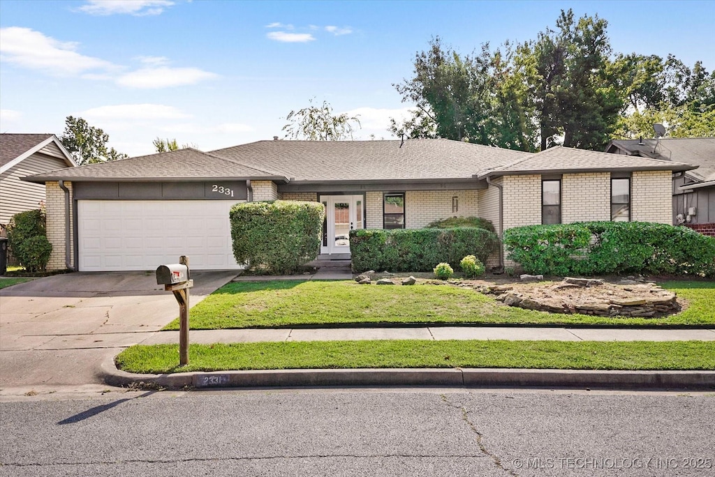 ranch-style home with a front yard and a garage