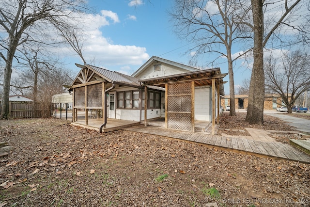 rear view of house featuring a sunroom