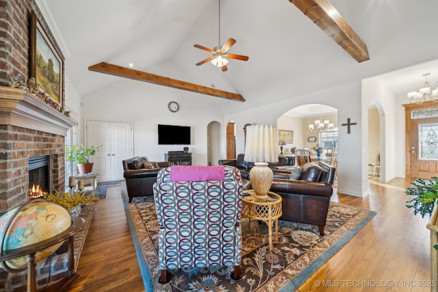 living room with hardwood / wood-style floors, a fireplace, high vaulted ceiling, ceiling fan with notable chandelier, and beamed ceiling