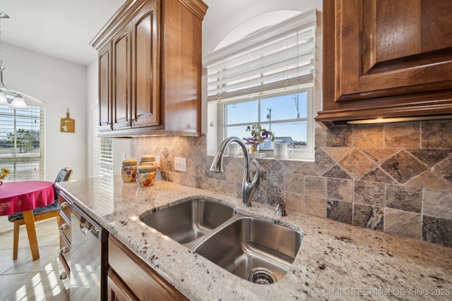 kitchen with decorative backsplash, dishwasher, light stone counters, and sink