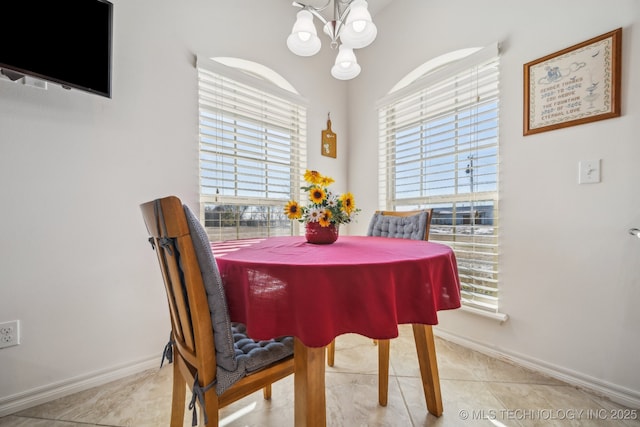 dining space with light tile patterned floors and an inviting chandelier