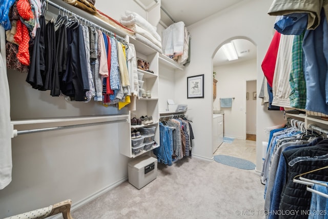 walk in closet with light colored carpet