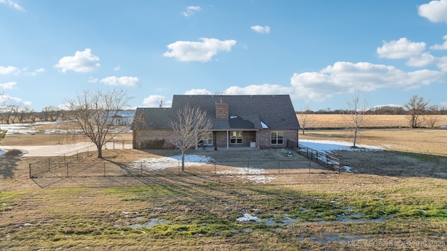 rear view of property featuring a rural view, a lawn, and a patio