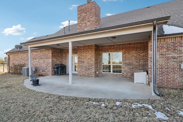 rear view of property with cooling unit and a patio