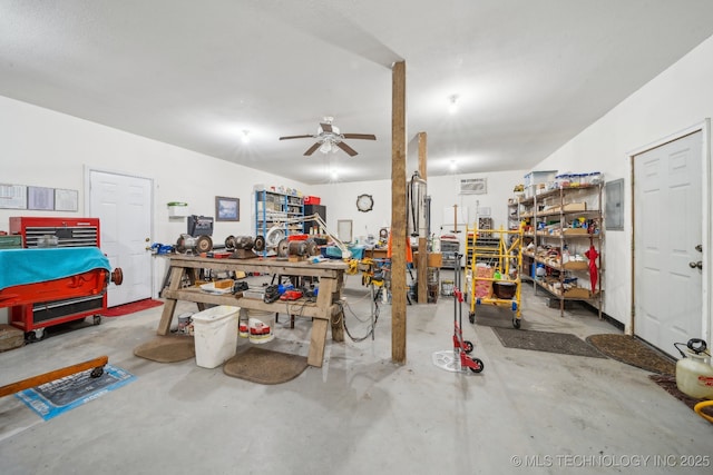 misc room featuring ceiling fan, electric panel, concrete floors, and a workshop area