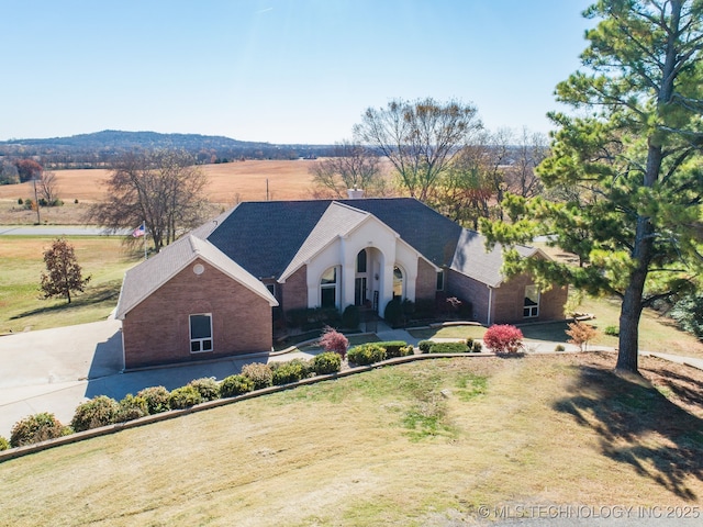 view of front of house featuring a front lawn and a rural view