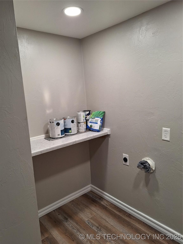 laundry area with electric dryer hookup and dark wood-type flooring