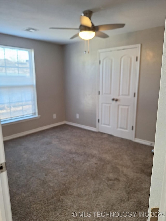 carpeted empty room featuring ceiling fan