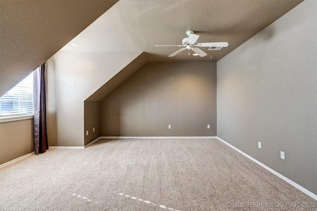 bonus room with light carpet, vaulted ceiling, a textured ceiling, and ceiling fan