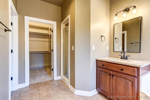 bathroom featuring vanity, tile patterned flooring, and walk in shower