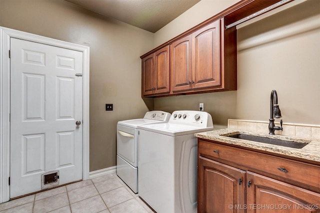 laundry room with washing machine and dryer, cabinets, light tile patterned flooring, and sink