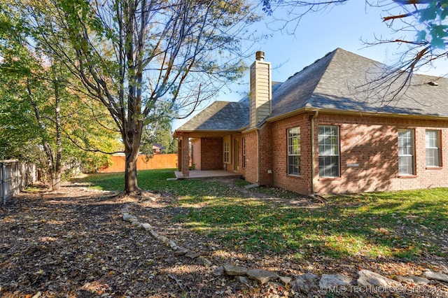 view of property exterior with a yard and a patio