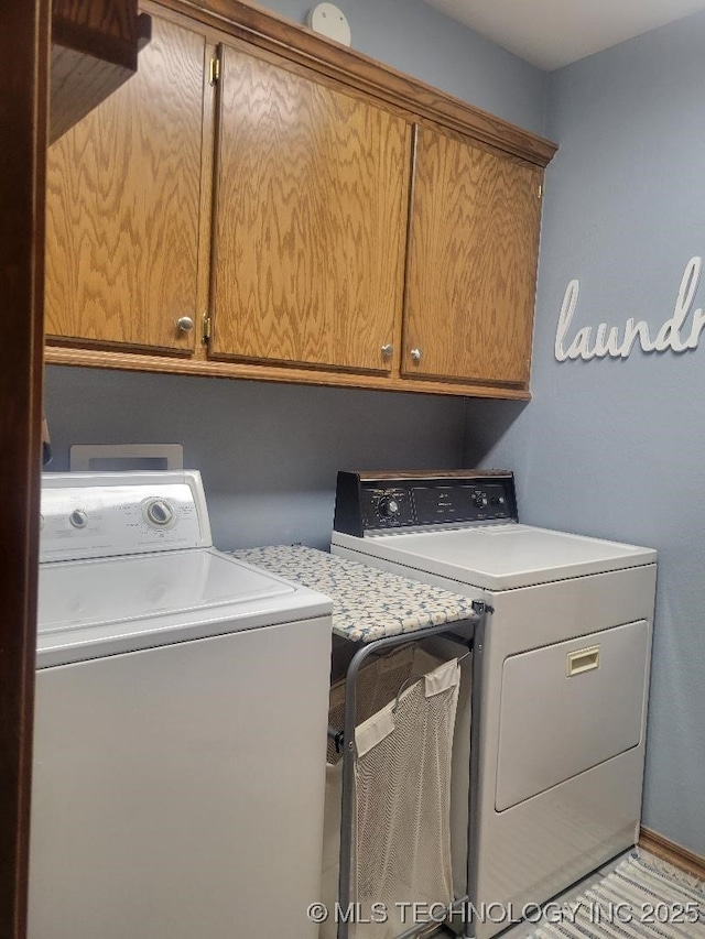 washroom with independent washer and dryer and cabinets