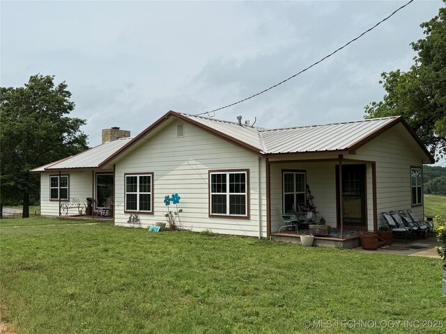5804 Samuel Rd, Kingston, OK 73439 - back of house featuring a chimney, a yard, metal roof, and a patio area
