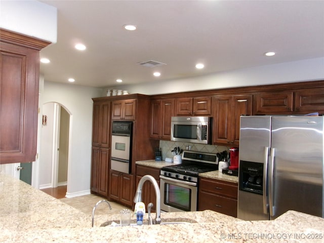 10500 W 123rd Rd, Oktaha, OK 74450 - kitchen with stainless steel appliances, light stone counters, tasteful backsplash, and sink