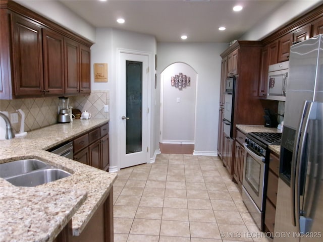 10500 W 123rd Rd, Oktaha, OK 74450 - kitchen with light tile patterned floors, stainless steel appliances, tasteful backsplash, light stone countertops, and sink