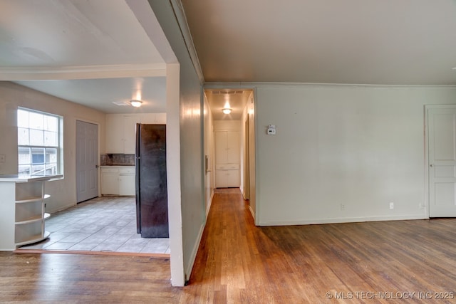 corridor with light wood-type flooring and crown molding