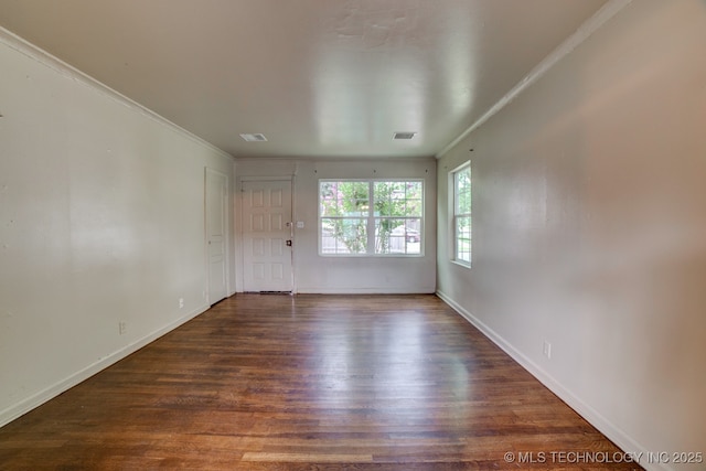 empty room with dark hardwood / wood-style flooring and ornamental molding