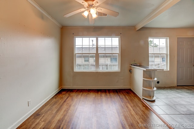 empty room with ceiling fan, crown molding, and hardwood / wood-style flooring