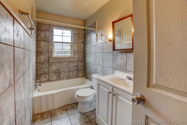 full bathroom featuring tiled shower / bath combo, tile patterned flooring, vanity, tile walls, and toilet