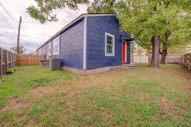 exterior space with central air condition unit and a yard