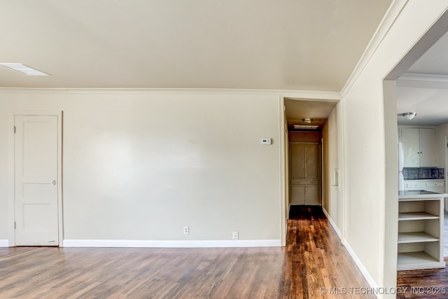 spare room with crown molding and dark hardwood / wood-style floors