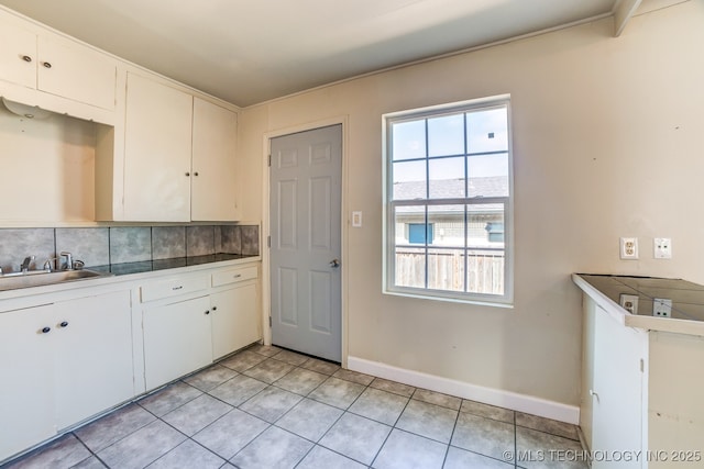 kitchen with white cabinets, backsplash, and plenty of natural light