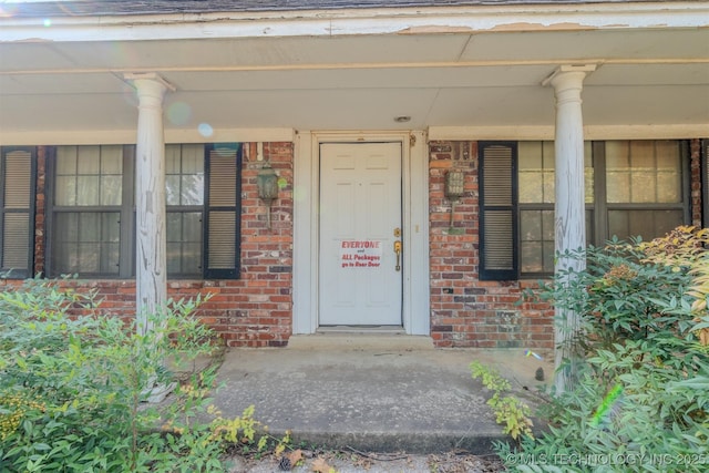 doorway to property with brick siding