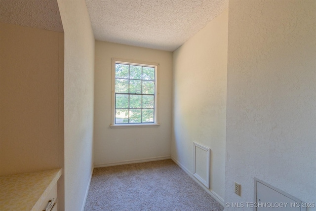 carpeted spare room featuring a textured ceiling