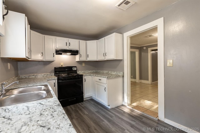 kitchen with sink, white cabinetry, dark hardwood / wood-style flooring, and gas stove