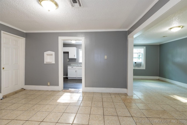 tiled spare room with a textured ceiling, crown molding, and cooling unit