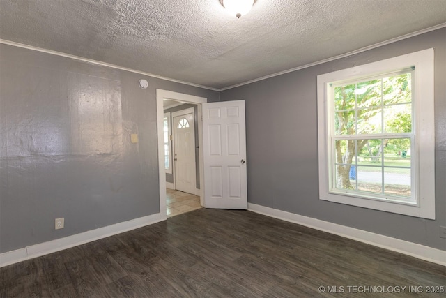 unfurnished room with dark hardwood / wood-style flooring, ornamental molding, and a textured ceiling