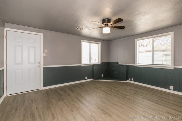 unfurnished room with ceiling fan, plenty of natural light, a textured ceiling, and hardwood / wood-style floors