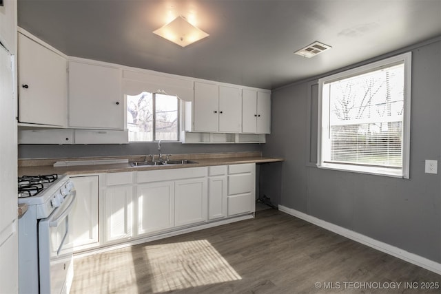 kitchen featuring white cabinetry, sink, dark hardwood / wood-style flooring, and white gas stove