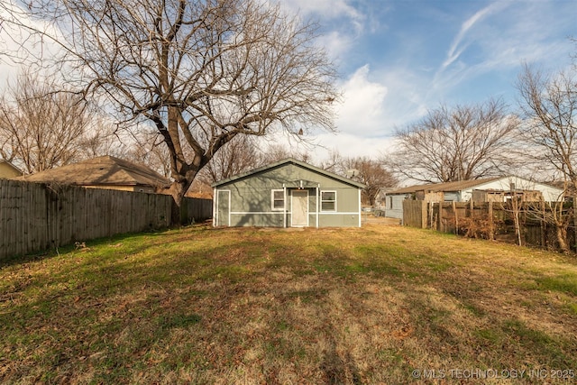 back of house featuring an outbuilding and a yard