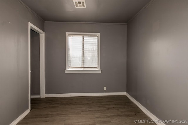 spare room with dark wood-type flooring and crown molding