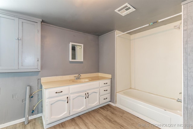 bathroom with vanity, tub / shower combination, and hardwood / wood-style flooring